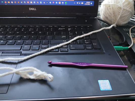looped crochet yarn on a laptop